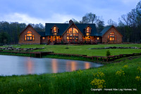 Exterior, horizontal, front elevation at twilight with pond in foreground, Wilson residence, Crossville, Tennessee; Honest Abe Log Homes