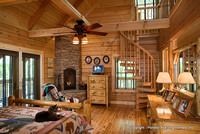 Interior, horizontal, master bedroom toward fireplace with cat on bed, Marshall residence, Grand Vista Bay, Rockwood, Tennessee, Honest Abe Log Homes