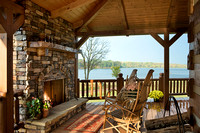 Exterior, horizontal, fireplace and sitting on rear deck at twilight looking out to Five Fingers Lake, DeSocio residence, Paris, Tennessee; Honest Abe Log Homes